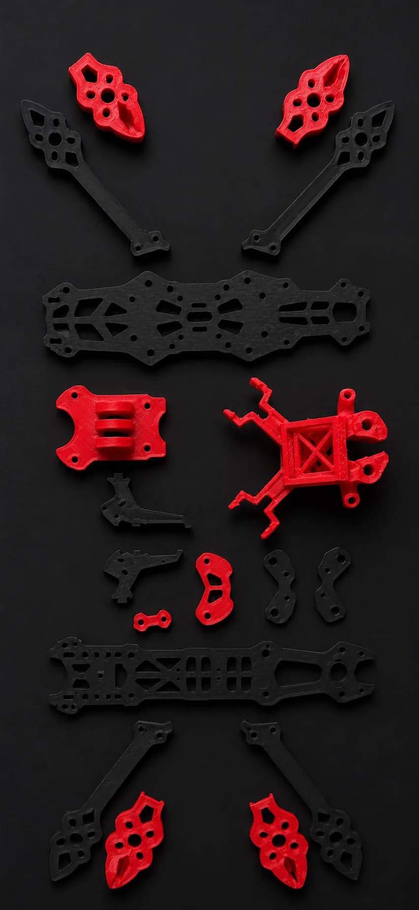 DronesZ 5-inch FPV airframe, exploded flat-lay of its modular carbon fiber and red 3D-printed components.
