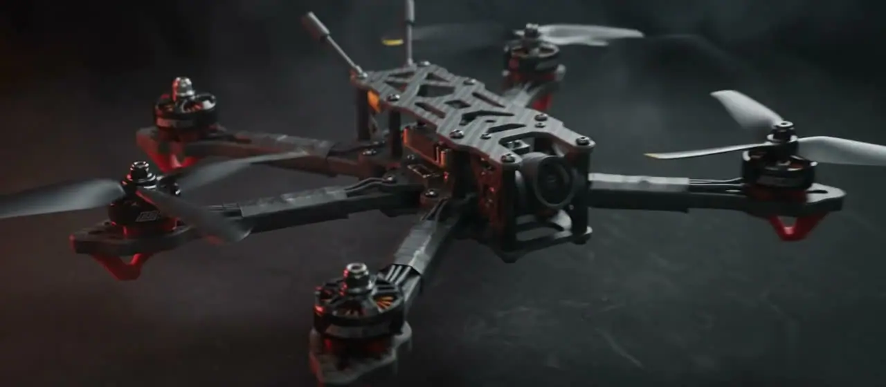 A DronesZ 5-inch FPV drone, fully assembled in a matte studio void with red rim light.